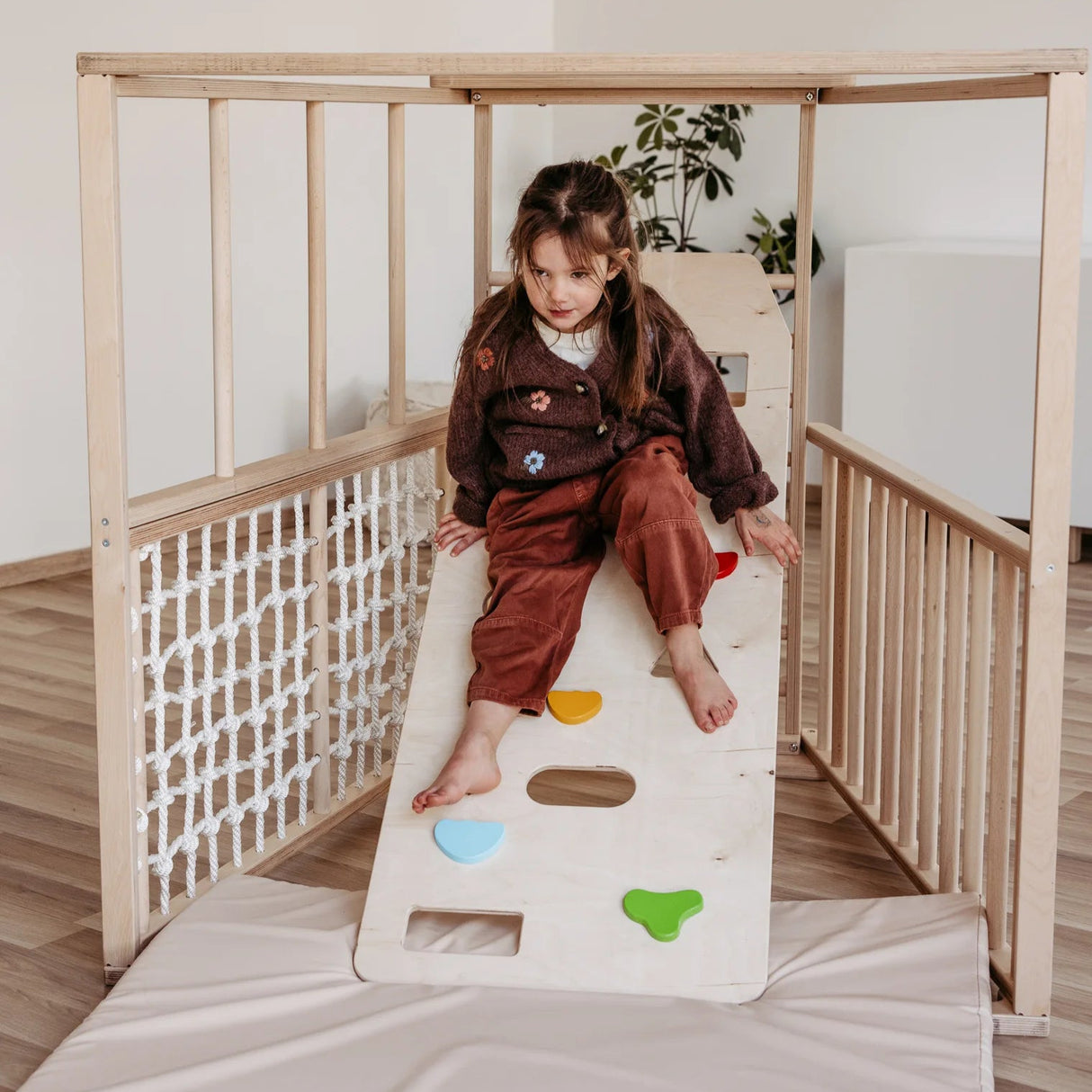 Cliff climbing wall mounted on indoor climbing frame for children